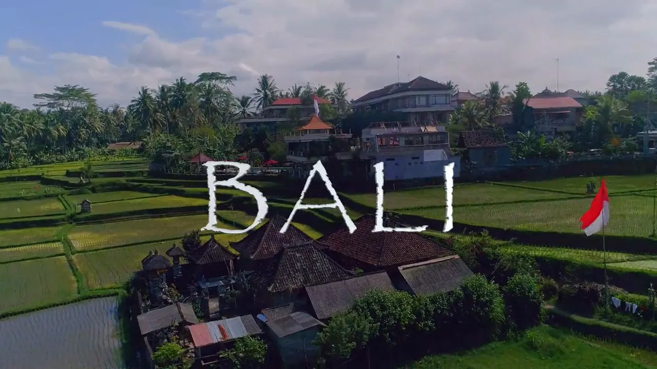 Aerial frame over green rice terraces and village rooftops with the word Bali set across it